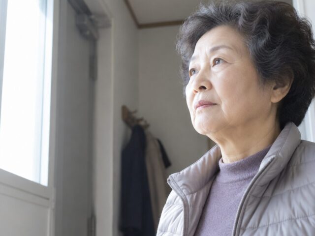 현관 벽 앞에 잠깐 멈춰 선 70대 어머니