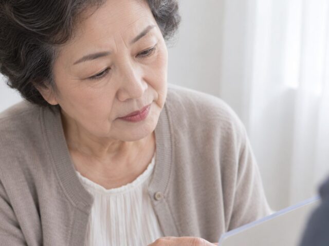 손주가 든 서류를 바라보는 70대 어머니
