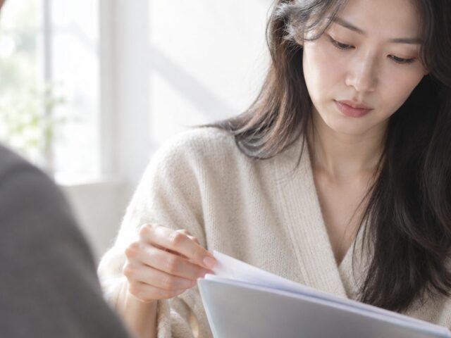 서류철을 넘기며 아래를 보는 아내의 모습