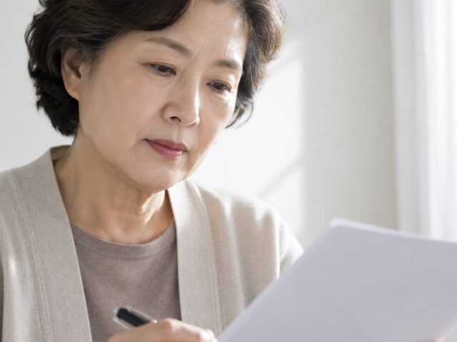 종이를 손에 들고 내려다보는 어르신